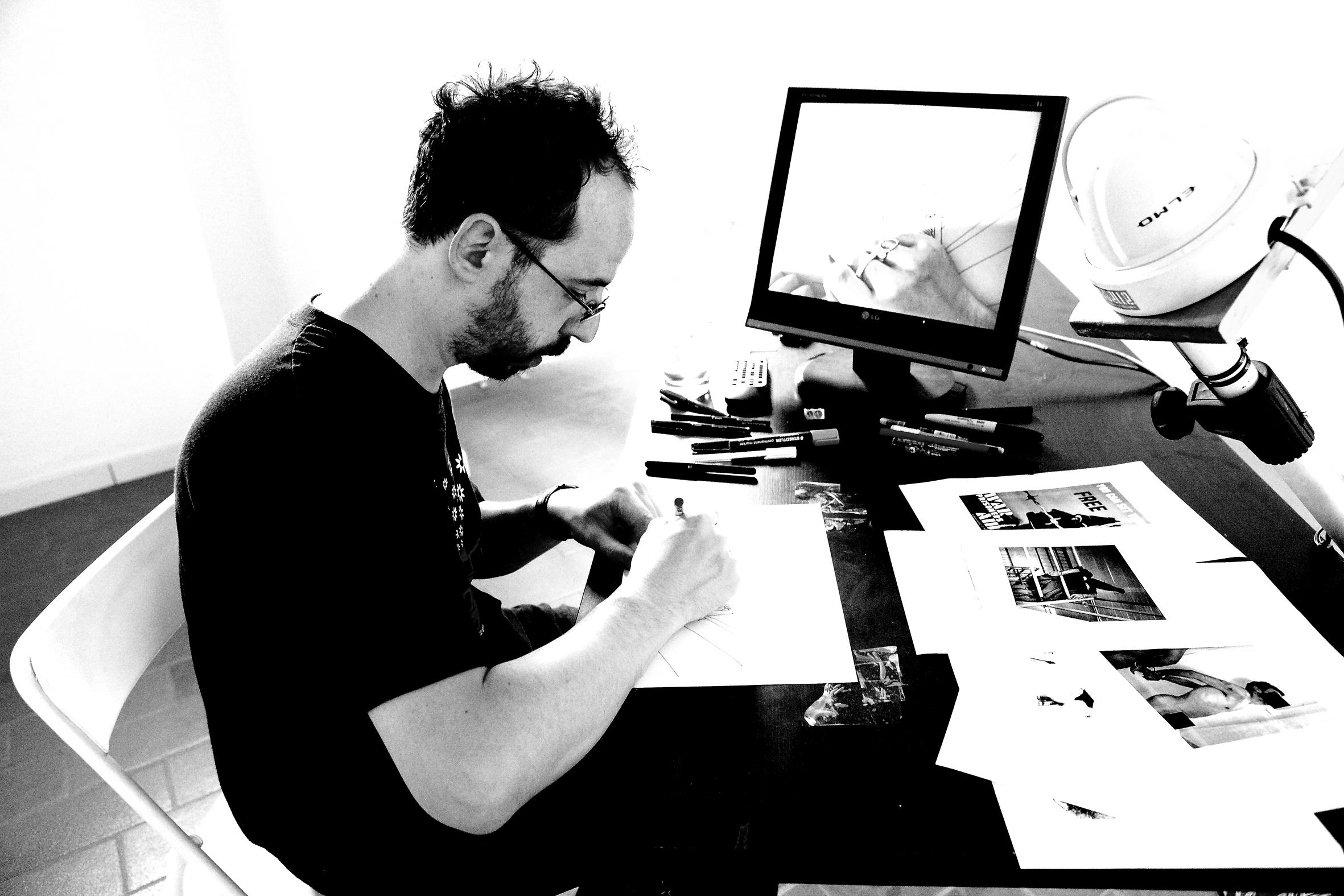 l'illustratore e giornalista Gianluca Costantini seduto a lavorare alla scrivania